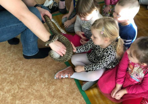 dzieci głaszczą węża